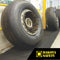 Firmagrip industrial matting supporting heavy aircraft tire, demonstrating wheel-proof construction for high-traffic areas